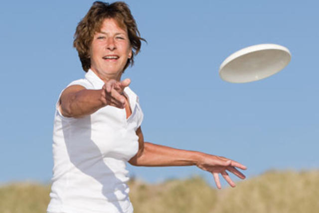 Woman throwing frisbee outside
